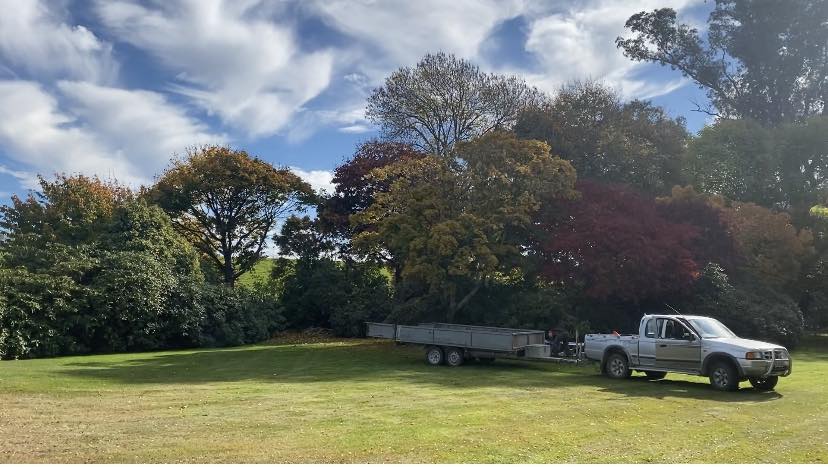 OT's Trees service vehicle and trailer beside established trees