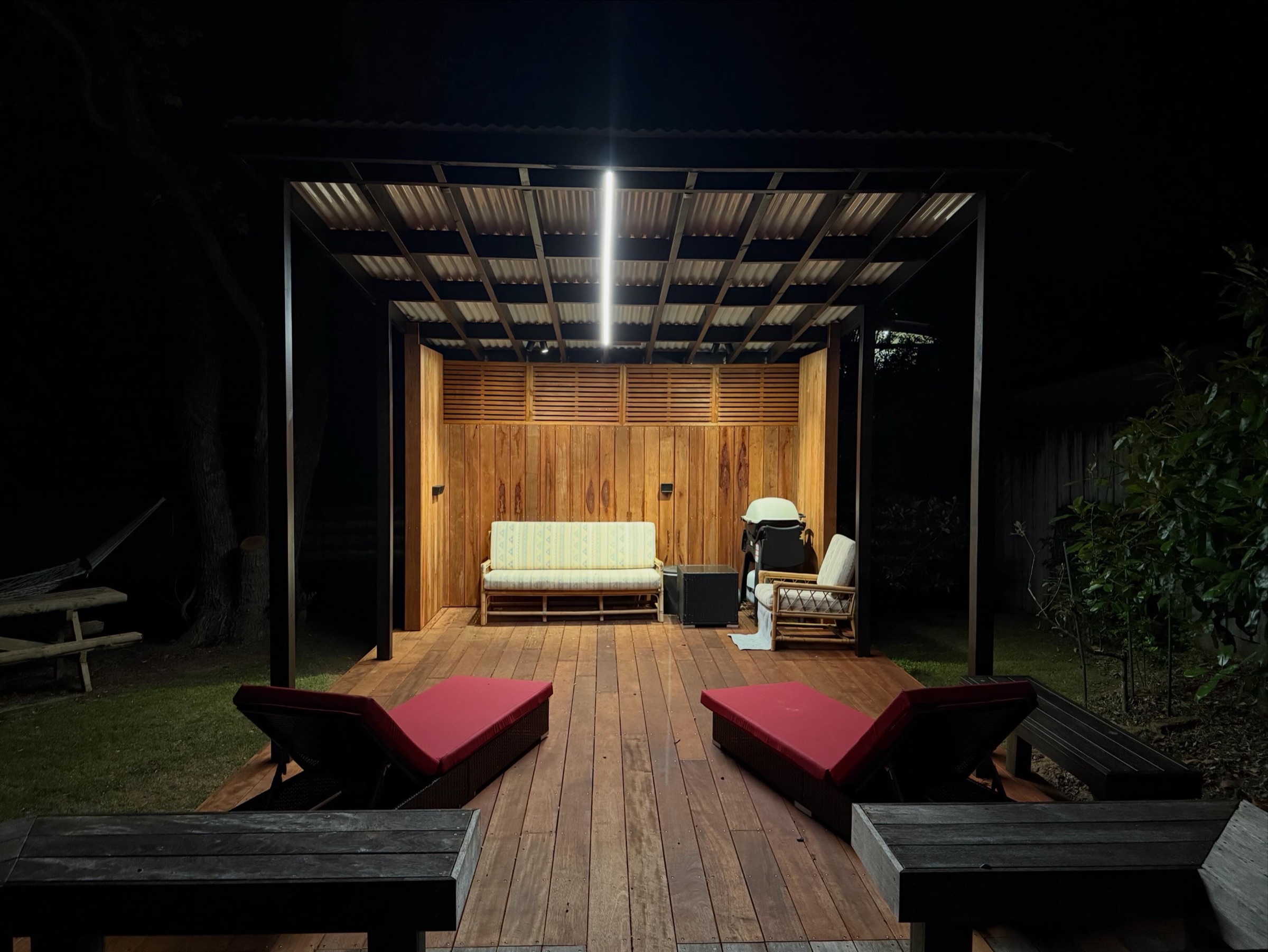 Covered timber deck illuminated at night